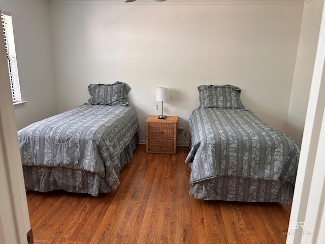 bedroom with multiple windows and wood finished floors