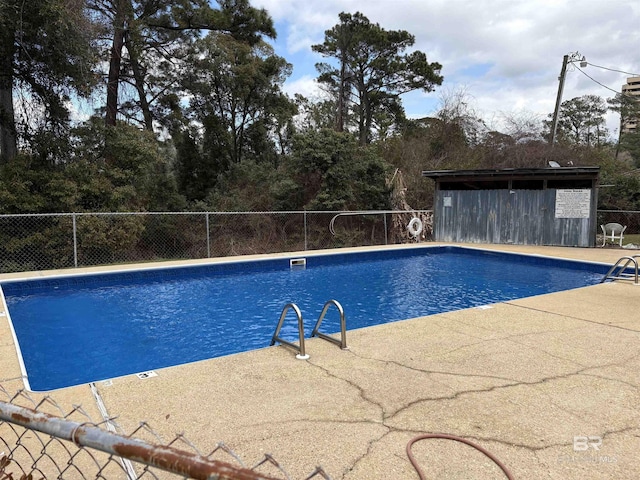 community pool with a patio and fence