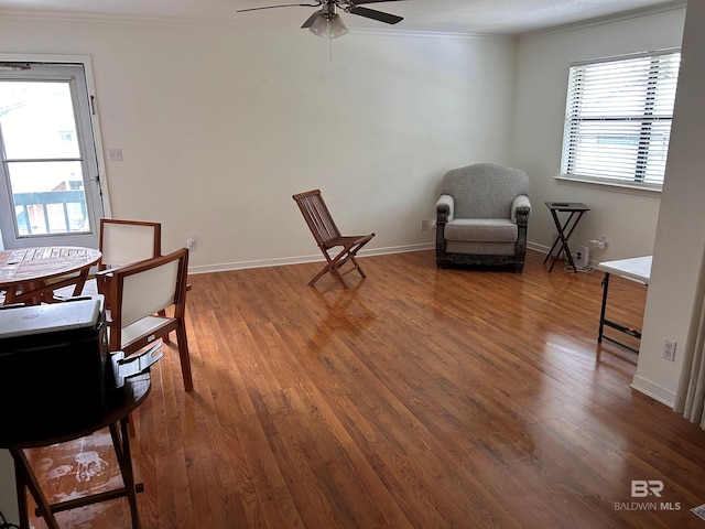 interior space featuring a healthy amount of sunlight, wood finished floors, baseboards, and ornamental molding