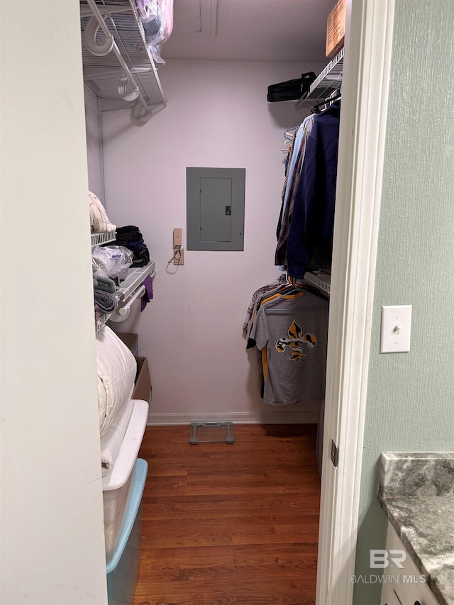 walk in closet with electric panel and wood finished floors