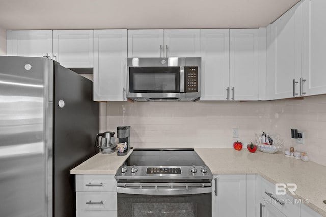 kitchen featuring white cabinets, tasteful backsplash, and stainless steel appliances