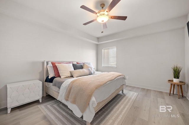 bedroom with light wood-style floors, baseboards, and a ceiling fan