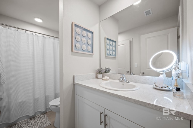 full bathroom featuring toilet, visible vents, and vanity