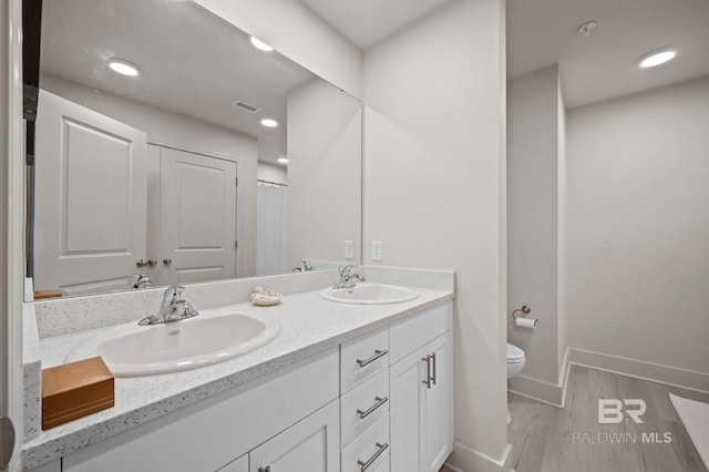 full bath with visible vents, wood finished floors, a sink, and toilet