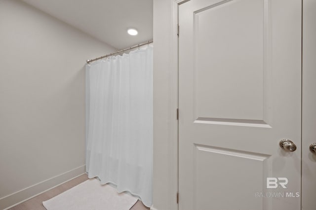 bathroom with a shower with shower curtain and baseboards