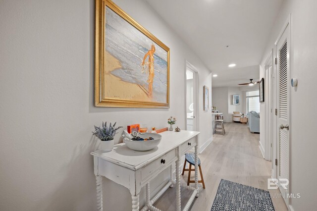 hallway with light wood-style floors, recessed lighting, and baseboards