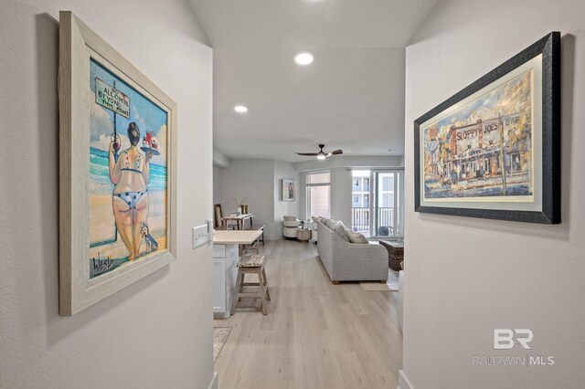 hall featuring light wood finished floors, baseboards, and recessed lighting