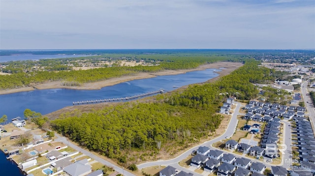 birds eye view of property featuring a water view and a wooded view