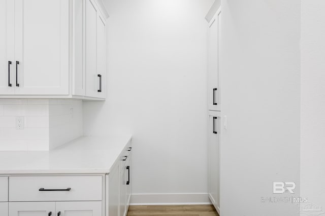 interior space featuring light wood-type flooring and baseboards