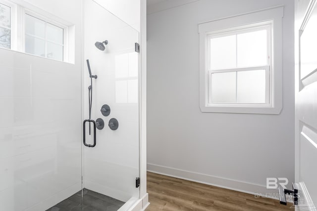 bathroom featuring a stall shower, baseboards, and wood finished floors