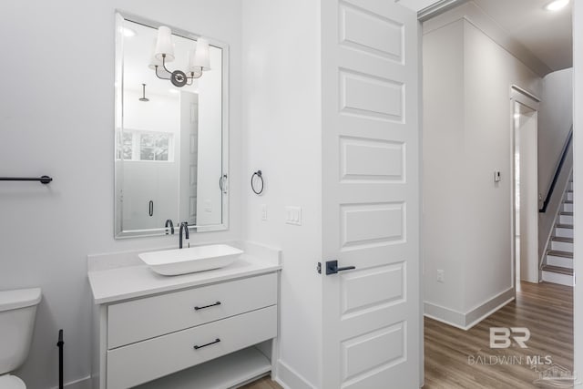 full bath with toilet, baseboards, wood finished floors, and vanity