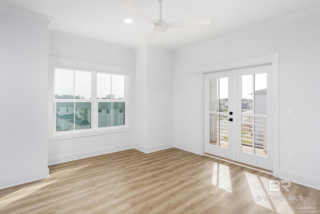 empty room featuring light wood finished floors, baseboards, crown molding, and french doors