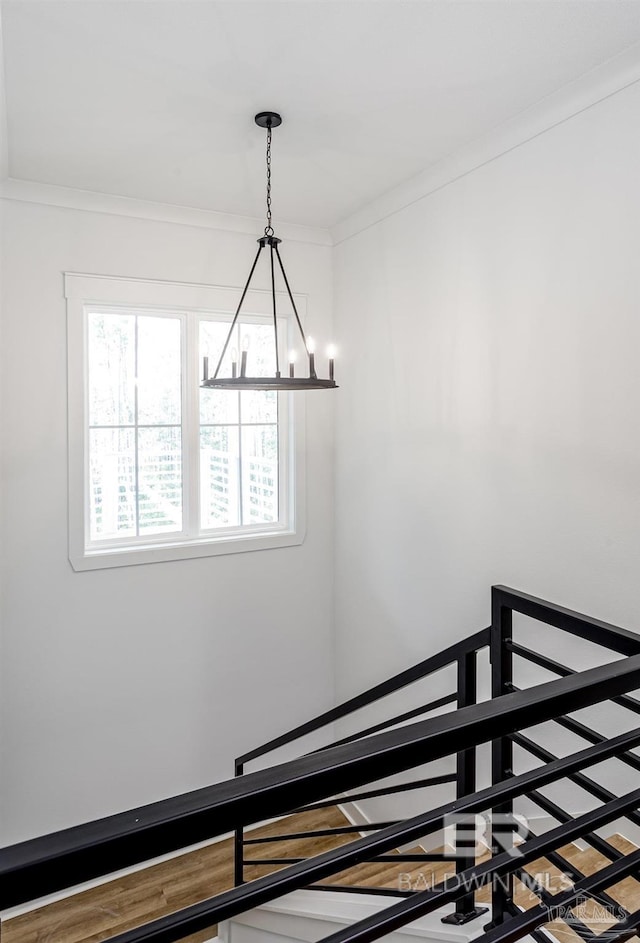 stairs featuring a chandelier and crown molding