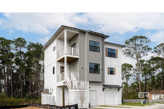 view of front facade featuring a garage, a balcony, metal roof, a standing seam roof, and board and batten siding