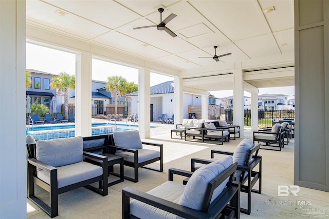 view of patio with outdoor lounge area, fence, a community pool, and a ceiling fan