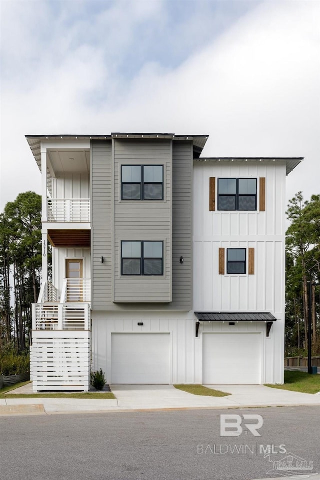 view of front of home with a garage, concrete driveway, board and batten siding, and a balcony