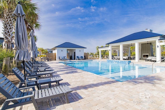 pool with a patio, ceiling fan, an outbuilding, a storage structure, and fence