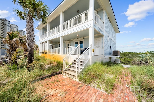 view of front of house with a balcony and central AC unit