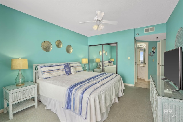 carpeted bedroom with connected bathroom, a closet, and ceiling fan