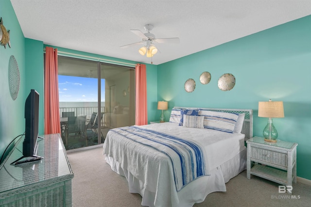 carpeted bedroom with access to exterior, ceiling fan, and a textured ceiling