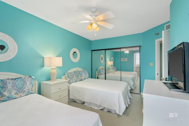 bedroom featuring light carpet, a closet, and ceiling fan