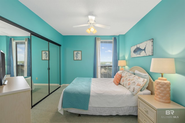 bedroom with multiple windows, ceiling fan, and a closet