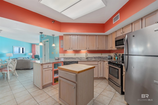kitchen with appliances with stainless steel finishes, light brown cabinets, sink, light tile floors, and a kitchen island