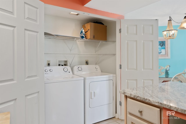 washroom featuring washer hookup, light tile floors, electric dryer hookup, an inviting chandelier, and washing machine and dryer