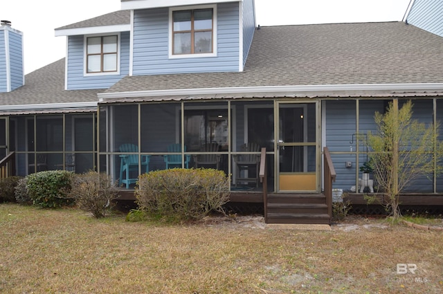 back of house featuring a sunroom and a lawn