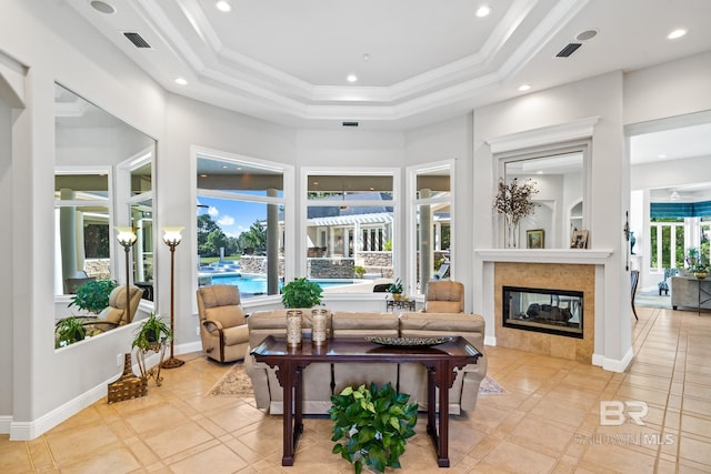 living room featuring a wealth of natural light, a fireplace, and a raised ceiling