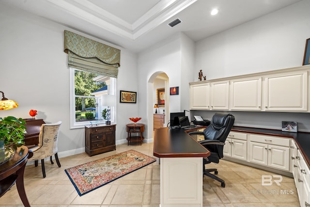 home office with ornamental molding, built in desk, and light tile patterned floors