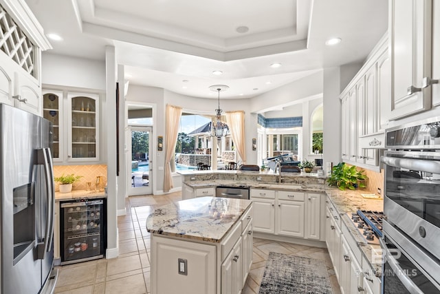 kitchen with wine cooler, pendant lighting, a center island, stainless steel appliances, and kitchen peninsula