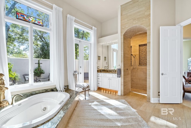 bathroom featuring tile patterned floors, french doors, independent shower and bath, and vanity