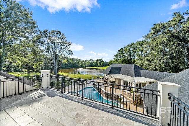 view of patio featuring a water view and a fenced in pool