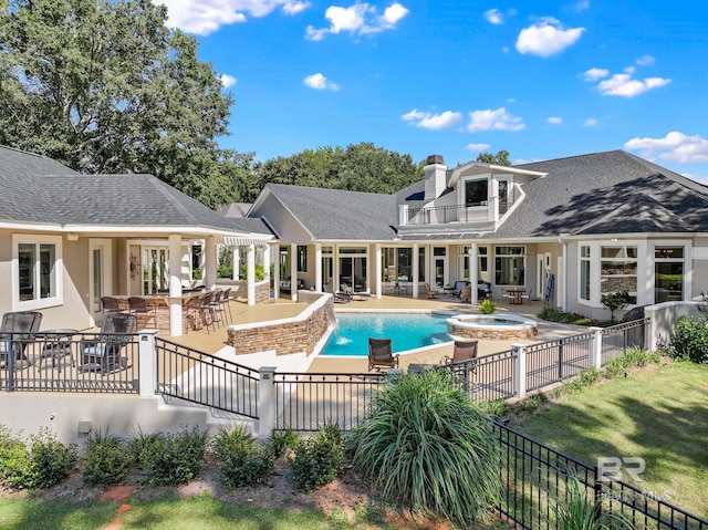 view of swimming pool featuring a bar, an in ground hot tub, a lawn, and a patio area