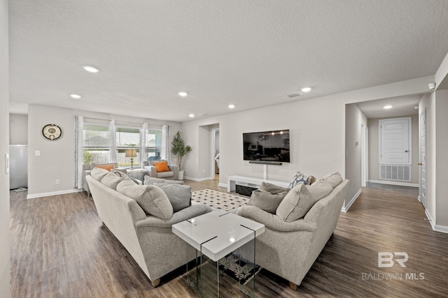 living room featuring a textured ceiling and dark hardwood / wood-style flooring