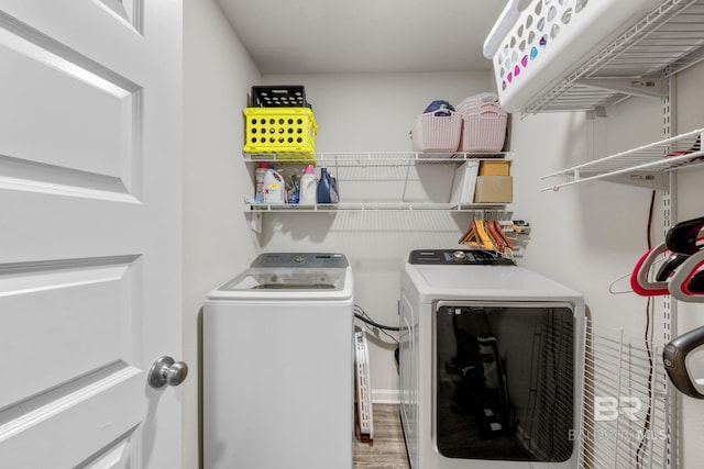 clothes washing area with wood-type flooring and independent washer and dryer