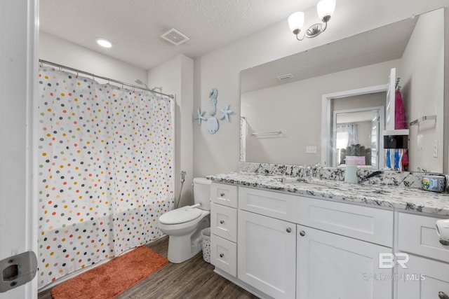 bathroom featuring vanity, curtained shower, a textured ceiling, hardwood / wood-style flooring, and toilet