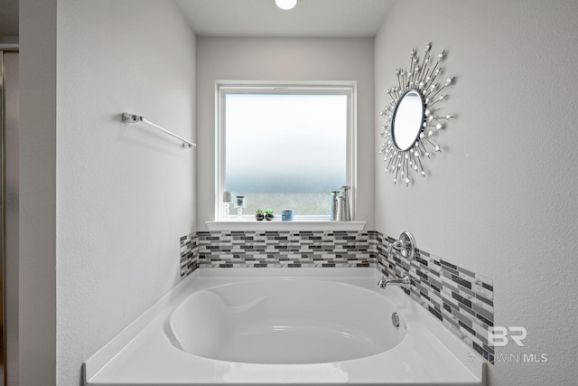 bathroom featuring a bath and plenty of natural light