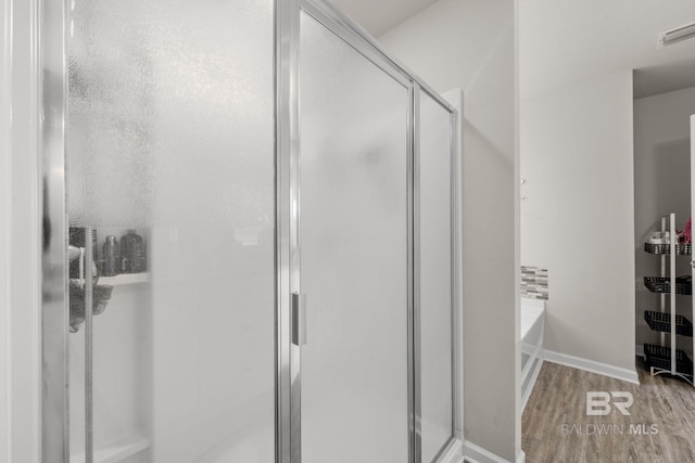 bathroom with wood-type flooring and separate shower and tub