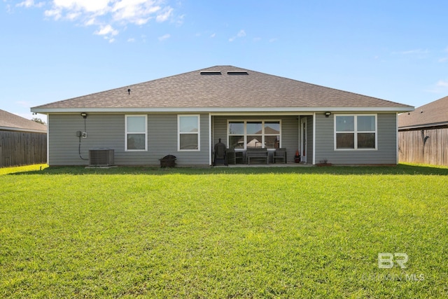 back of house featuring a lawn, central AC unit, and a patio area