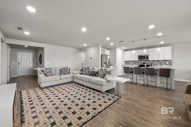 living room with a textured ceiling and hardwood / wood-style flooring