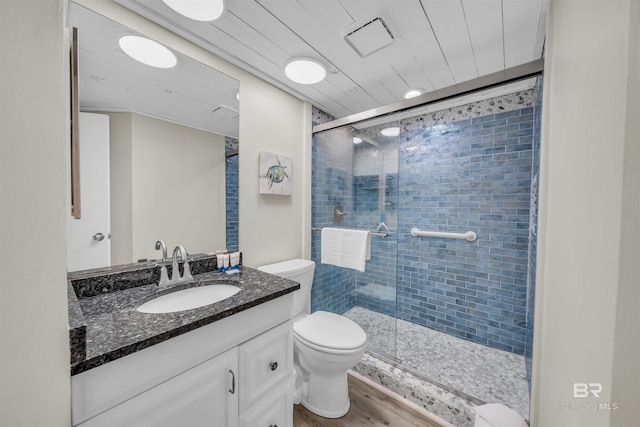 bathroom featuring vanity, toilet, wood-type flooring, and walk in shower