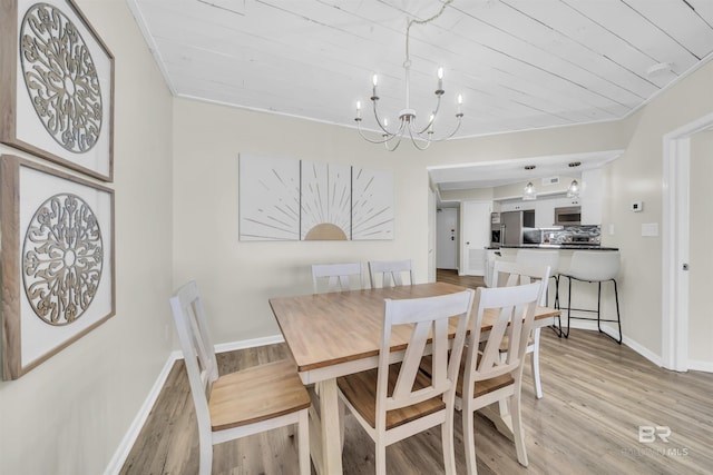 dining room featuring ornamental molding, light hardwood / wood-style floors, an inviting chandelier, and wooden ceiling