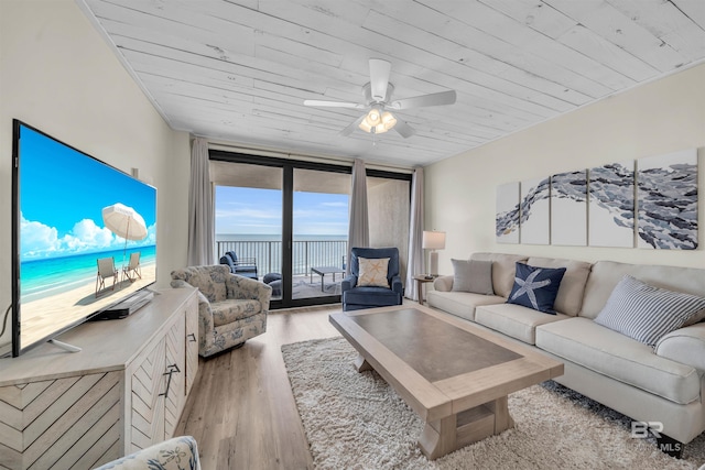 living room featuring light hardwood / wood-style floors, a wall of windows, wooden ceiling, and ceiling fan