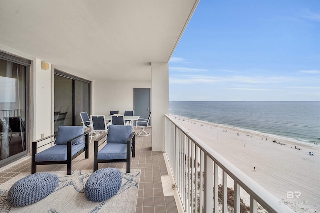 balcony with a water view and a view of the beach