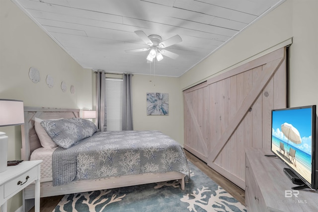 bedroom with ceiling fan, light hardwood / wood-style floors, and wood ceiling