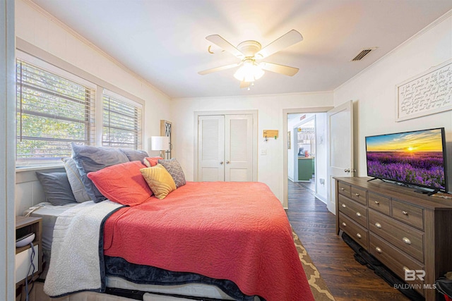 bedroom featuring crown molding, dark wood-type flooring, a closet, and ceiling fan