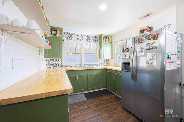 kitchen featuring dark wood-type flooring, butcher block counters, sink, green cabinetry, and stainless steel fridge