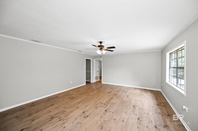 empty room featuring ornamental molding, a textured ceiling, ceiling fan, and light hardwood / wood-style floors